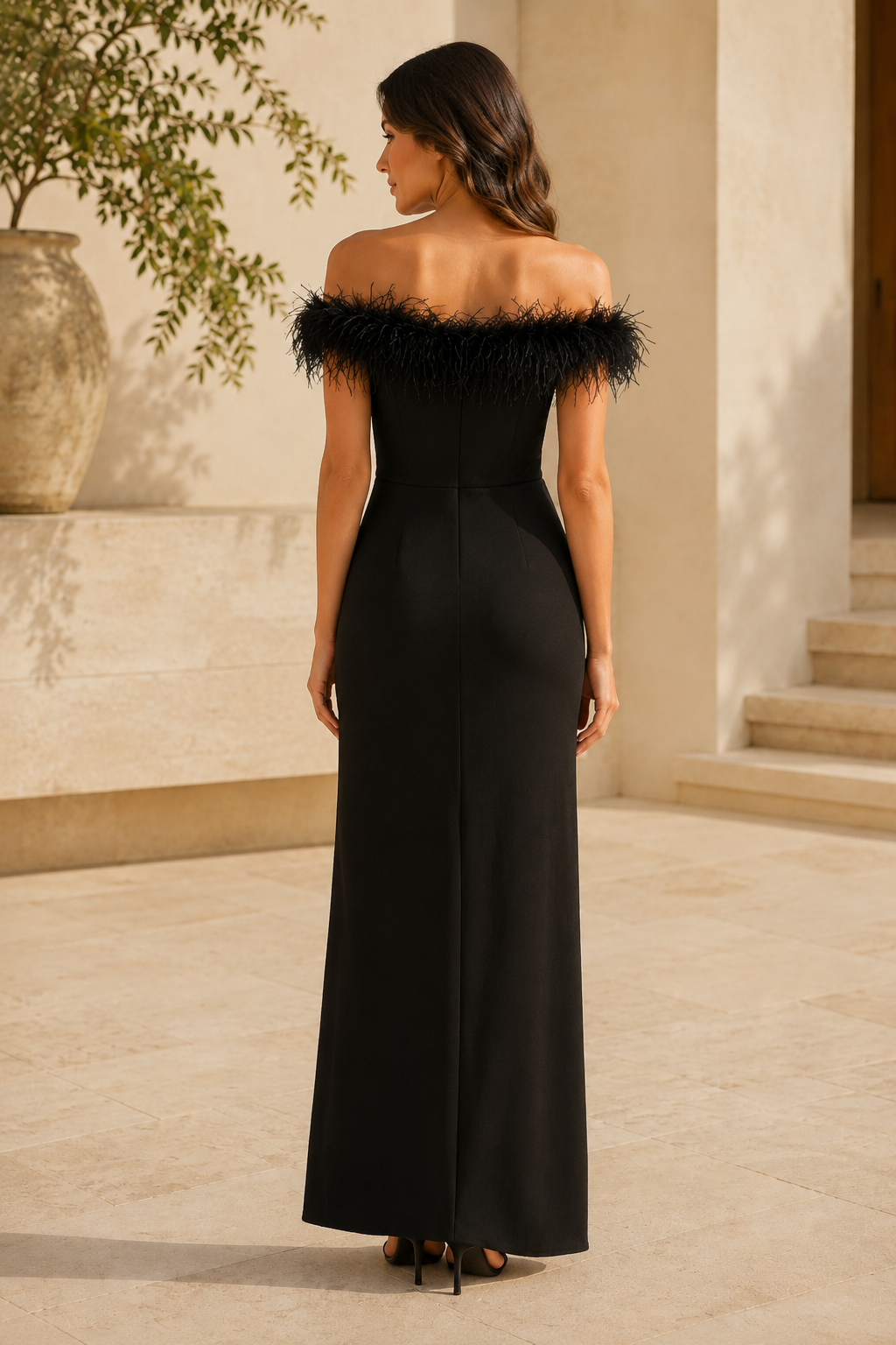 Vestido de noche con hombros descubiertos, plumas y abertura